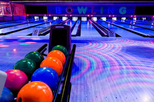 A vibrant bowling alley featuring colorful balls and polished lanes, showcasing the lively atmosphere of Skinny Dogz.