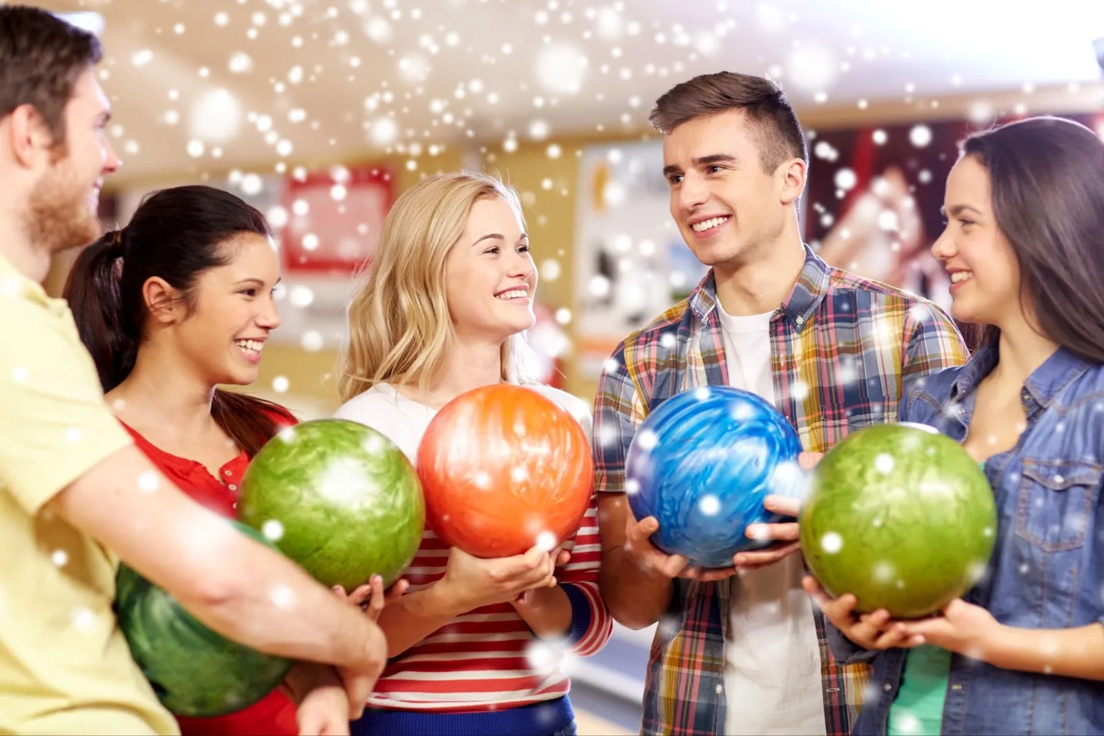 A group of friends laughing and enjoying themselves while playing bowling.