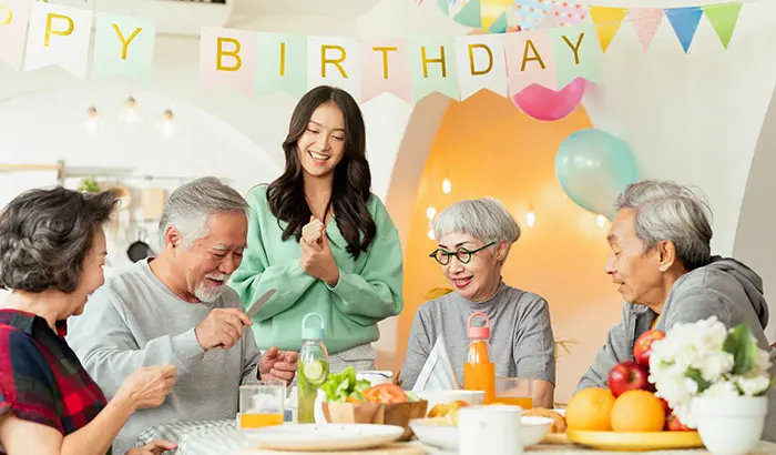 A joyful scene of friends singing a birthday song, surrounded by decorations and a cake, celebrating a beloved friend's birthday.