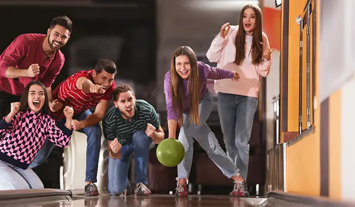 A group of people enjoying a game of bowling in a lively bowling alley.