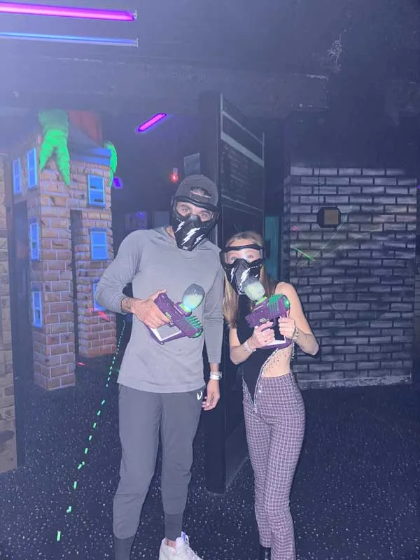 Gel_Blaster_games Two people wearing masks and holding a controller, playing video games together.