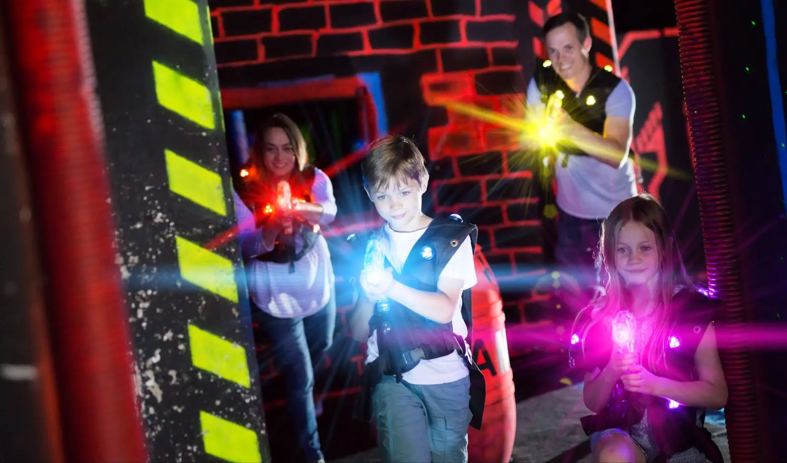 a family playing a laser gun in a  colorful light