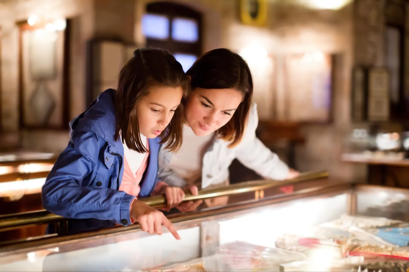 Two girls admiring jewelry at a museum, family fun at Skinny Dogz in Ogden, engaging in family activities