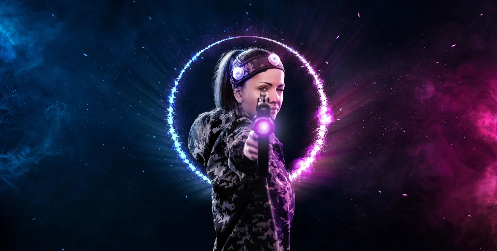 A woman surrounded by a vibrant purple and blue light, embodying the excitement of laser tag and paintball activities. A woman surrounded by a vibrant purple and blue light, embodying the excitement of laser tag and paintball activities.